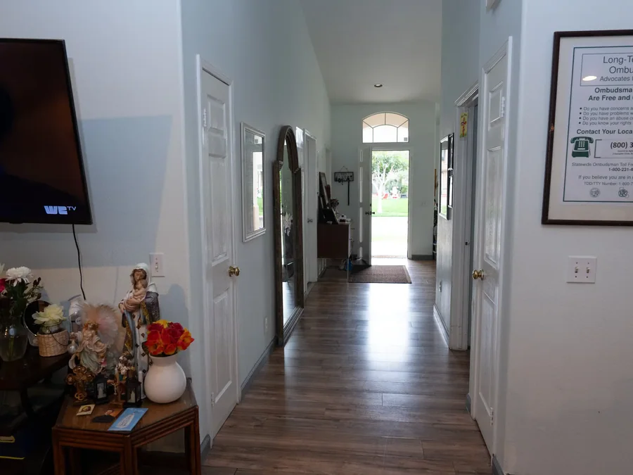Clean hallway with wood flooring leading to a bright entrance.