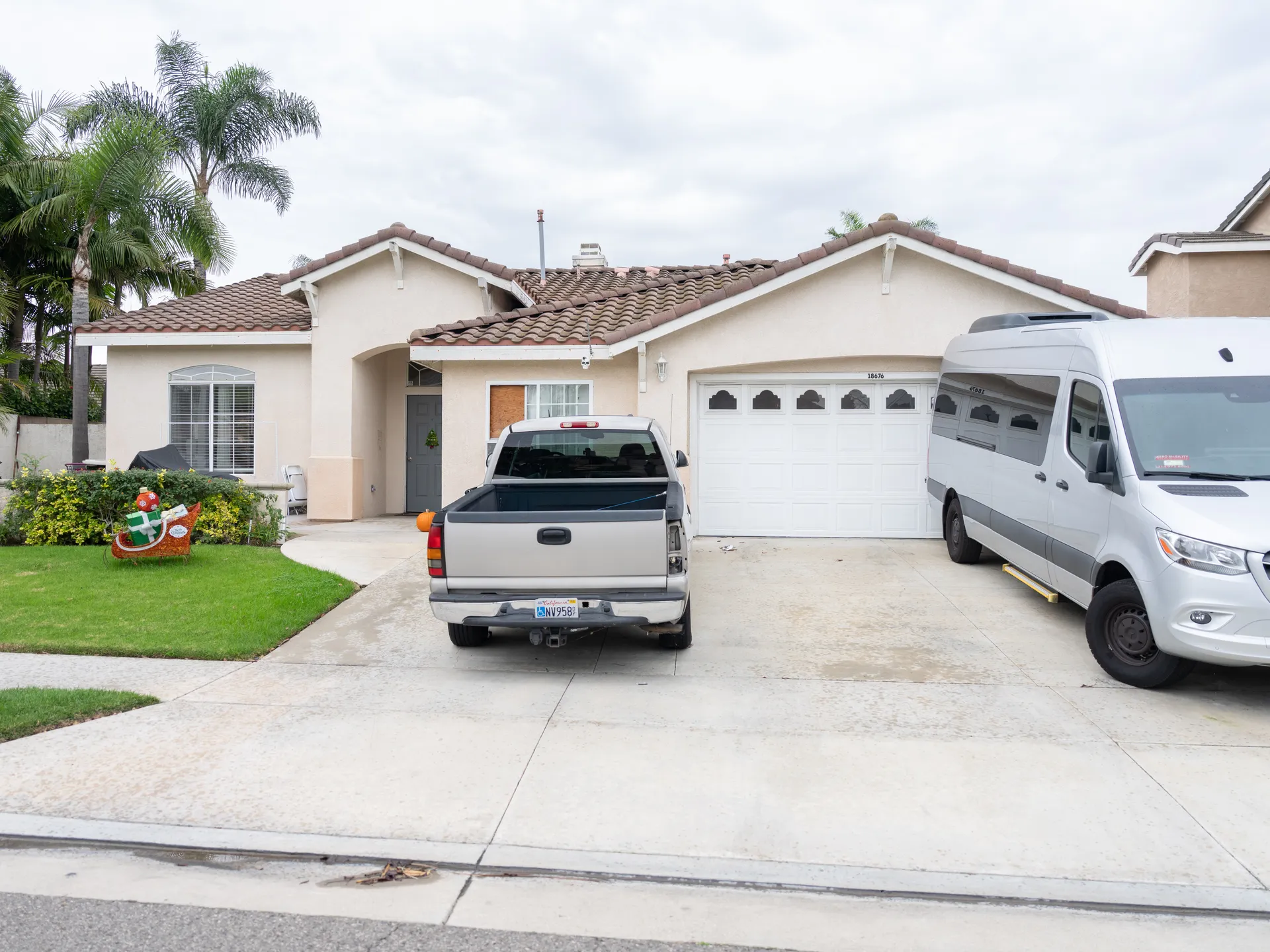 Exterior view of Santa Mariana Care single-story home with driveway and palm trees.